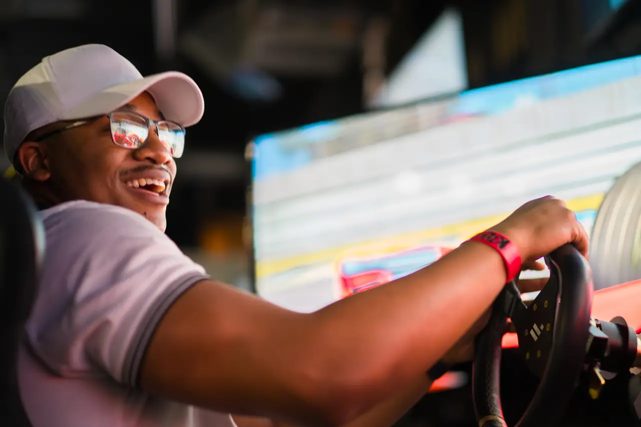 A guest grinning behind the wheel of a racing sim
